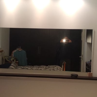 מראה גדולה על קיר עם השתקפות של חדר