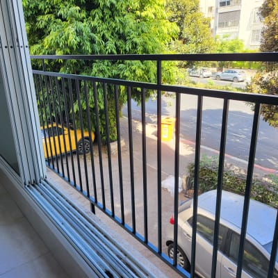מעקה ברזל שחור במרפסת עם חלונות זכוכית פתוחים
