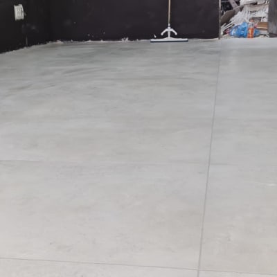 רצפת בטון חדשה עם כלי עבודה ברקע