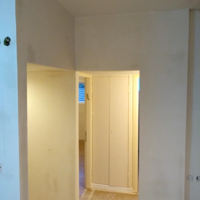 קירות צבועים בלבן עם סימני צבע על הרצפה