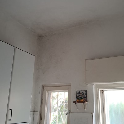 קיר עם סימני רטיבות ליד חלון במטבח