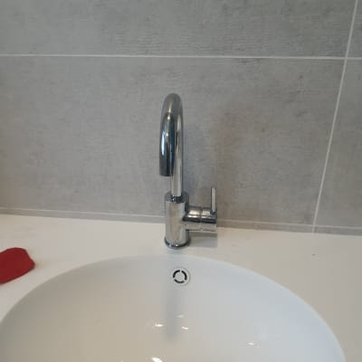 ברז כרום מעל כיור לבן בחדר אמבטיה