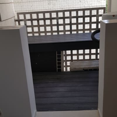 רצפת עץ חדשה במרפסת עם מעקה רשת