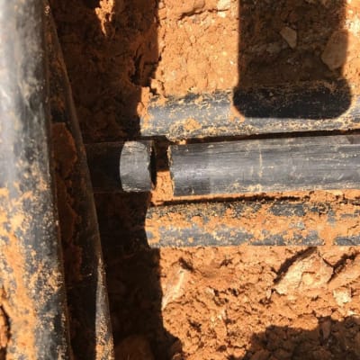 צינור שבור באדמה חומה עם צללים