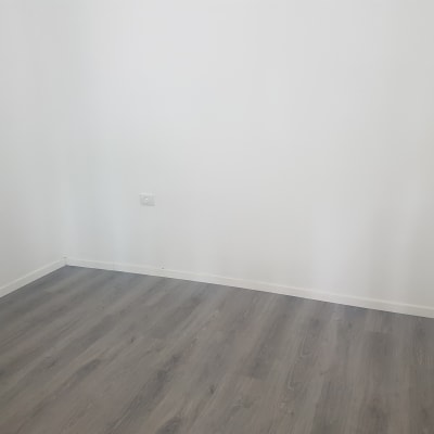 קיר לבן ורצפת עץ בחדר ריק