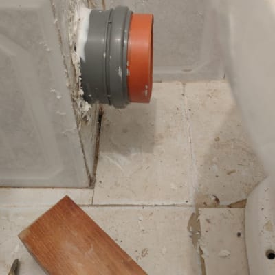 צינור ביוב אפור עם חיבור כתום בקיר