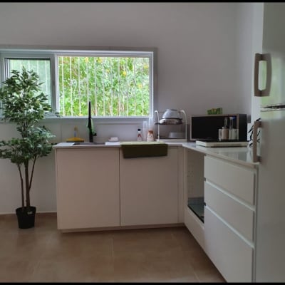 מטבח משופץ עם ארונות לבנים, כיור וברז מודרני