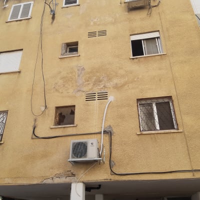 בניין עם מזגן חיצוני וחלונות עם סורגים