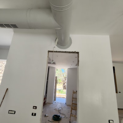 צינור אוורור אפור מותקן על תקרת גבס לבנה