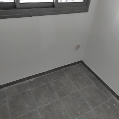 רצפה אפורה עם סימני אבק ליד חלון