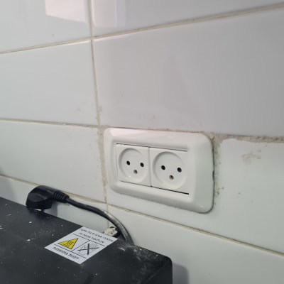 שקע חשמל כפול על קיר אריחים לבנים