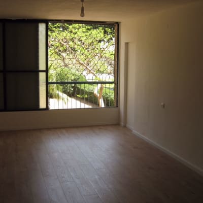 רצפת פרקט עץ בחדר ריק עם חלון גדול