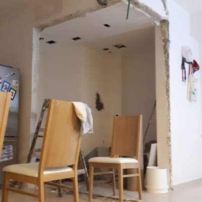 שיפוץ קיר עם חוטי חשמל חשופים וסולם