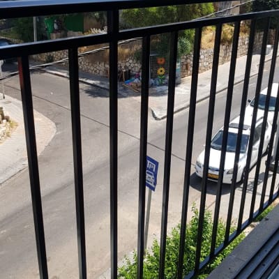 מעקה ברזל שחור במרפסת עם נוף לרחוב