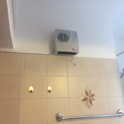 מאוורר חשמלי מותקן על קיר בחדר אמבטיה