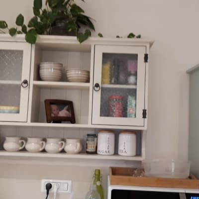 ארון מטבח עם כלים וצנצנות על מדף