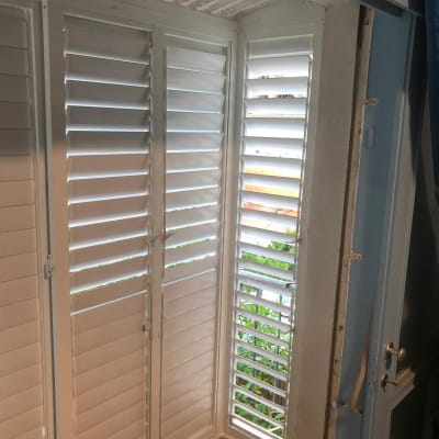 תריסי אלומיניום לבנים בחלון פינת חדר