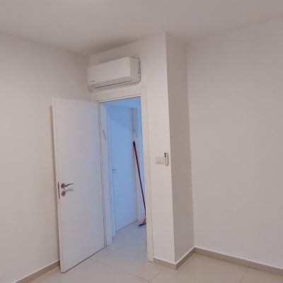 חדר עם קירות לבנים ודלת פתוחה