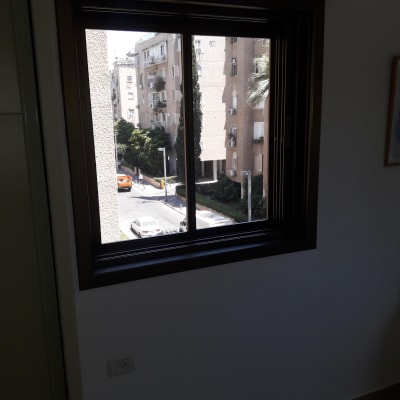 חלון אלומיניום עם נוף לבניינים ועצים