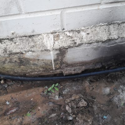 צינור שחור מחובר לקיר עם חיבור מתכת