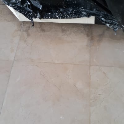 רצפה מלוכלכת עם כתמי צבע ושקית שחורה