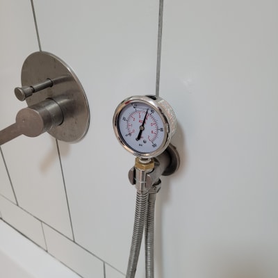 מד לחץ מחובר לצינור במקלחת