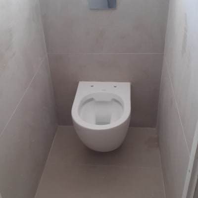 אסלה מותקנת בחדר שירותים עם קירות חדשים