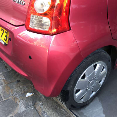 חלק אחורי של רכב אדום עם פגוש ופנס