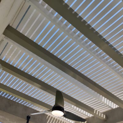 מאוורר תקרה תלוי מתחת לפרגולה מעץ