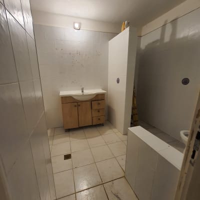 חדר אמבטיה עם אריחים לבנים, כיור וארון עץ