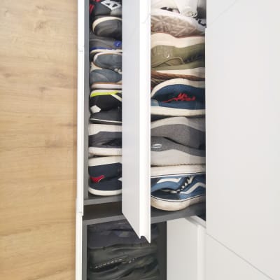 נעליים מסודרות בארון לבן עם מדפים נשלפים