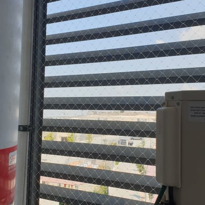 רשת מתכת על חלון למניעת כניסת יונים