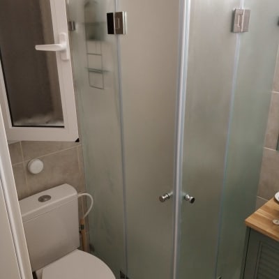 מקלחון זכוכית חדש ליד אסלה בחדר אמבטיה