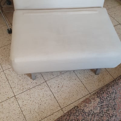 ספה בהירה על רצפת אריחים ליד שטיח מעוצב