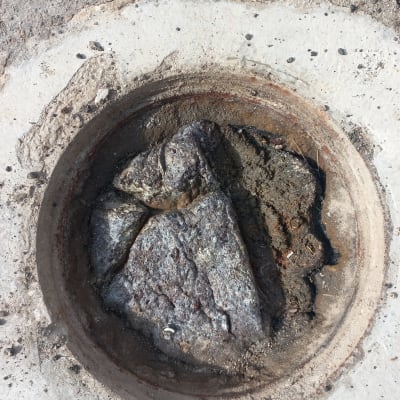 פתח ביוב עם סלעים ולכלוך