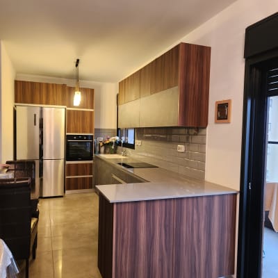 מטבח מודרני עם ארונות עץ, מקרר ותנור