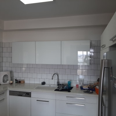 מטבח מודרני עם ארונות לבנים ומקרר נירוסטה