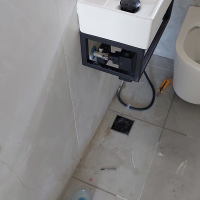 כיור עם כלים, ברז, צינור, כלי עבודה על הרצפה