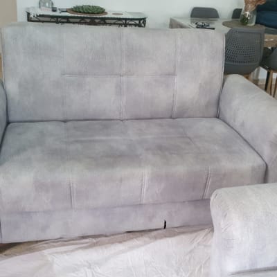 ספה אפורה עם דלי ומטליות לניקוי