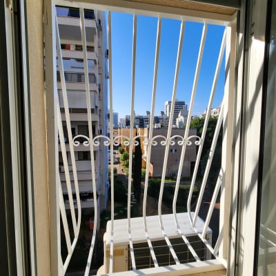 סורגי מתכת לבנים בחלון פתוח