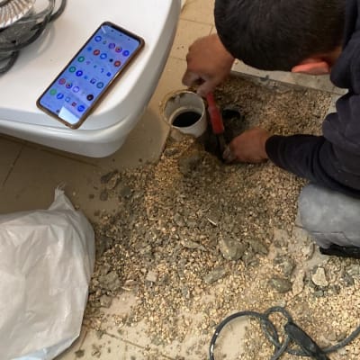 אדם עובד על צינור פתוח עם כלי עבודה