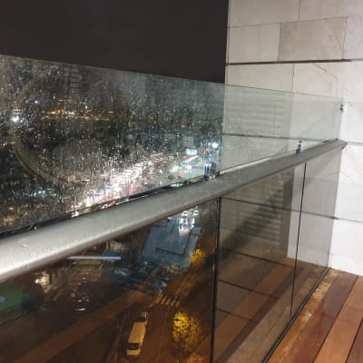 מעקה זכוכית רטוב עם טיפות גשם בלילה