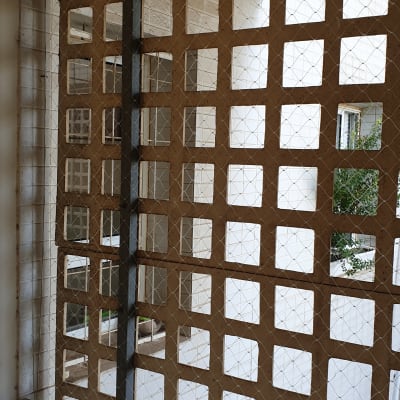 רשת מתכת מותקנת על חלון למניעת כניסת יונים