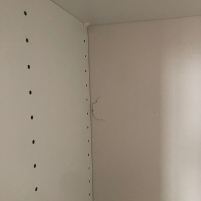 סדק בקיר פנימי של ארון עם חורים למדפים