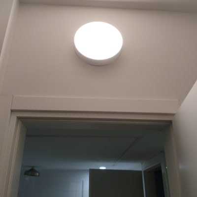 מנורת תקרה עגולה מוארת על קיר לבן