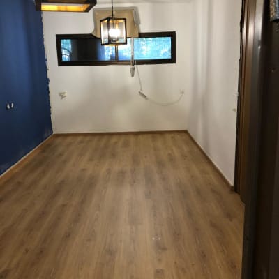 רצפת פרקט עץ בחדר עם קירות לבנים