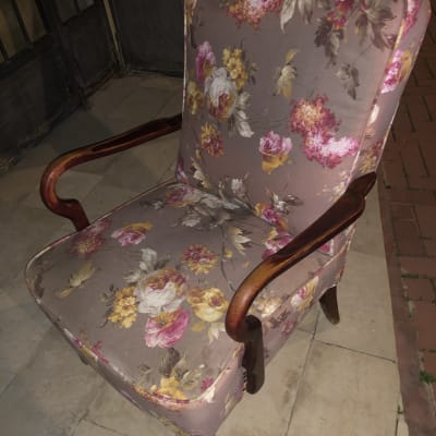 כורסה מרופדת בבד פרחוני צבעוני עם ידיות עץ