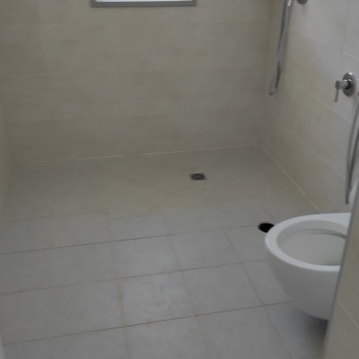 חדר רחצה עם מקלחון, אסלה ואריחים נקיים