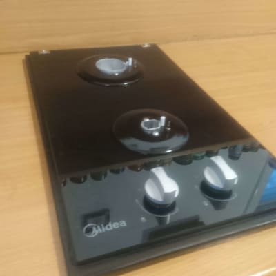 כיריים שחורות עם כפתורים לבנים על שולחן עץ