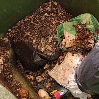 פסולת ואבנים בתוך מיכל ירוק